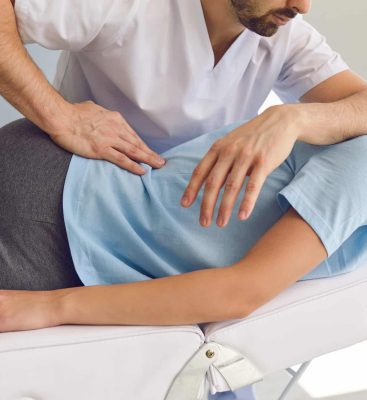 A chiropractor making an adjustment on a patient.