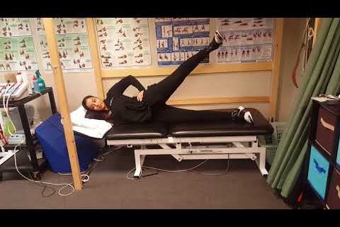 Someone demonstrating the sidelying hip abduction exercise.