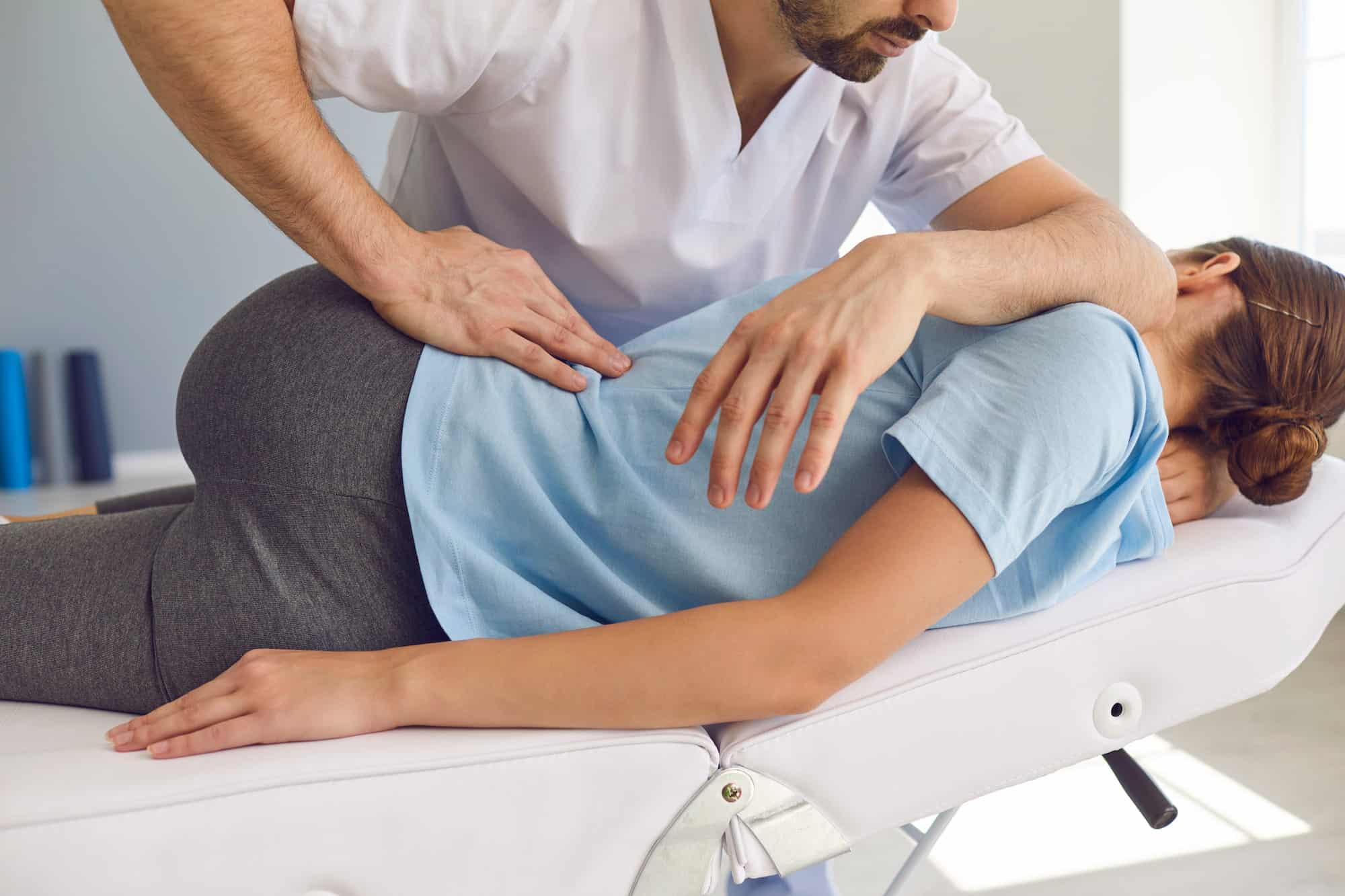 A chiropractor making an adjustment on a patient.