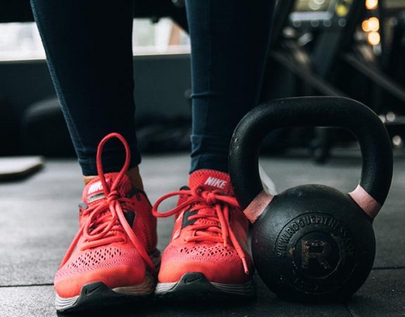 Exercise weight and a person's feet in running shoes