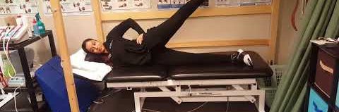 Someone demonstrating the sidelying hip abduction exercise.